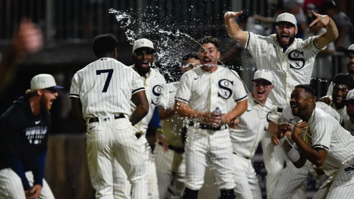 Tim Anderson's teammates celebrate as he crosses home plate